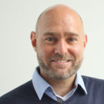 Portrait eines Mannes. Die Mann lächelt.